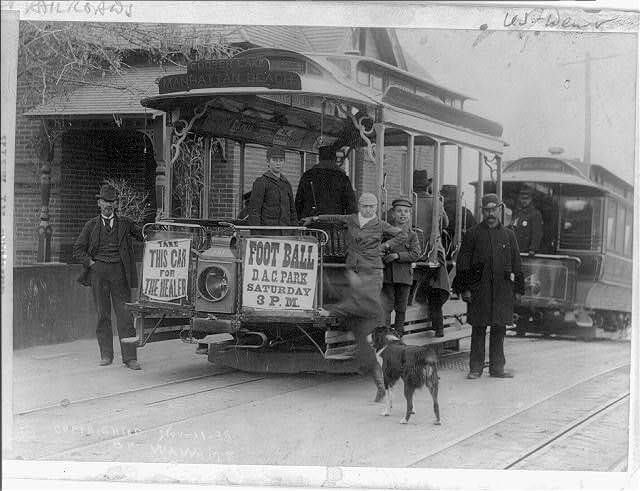 Men standing with streetcar.