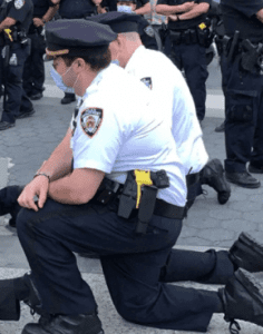 NYPD officer Robert Cattani kneels with protesters. 