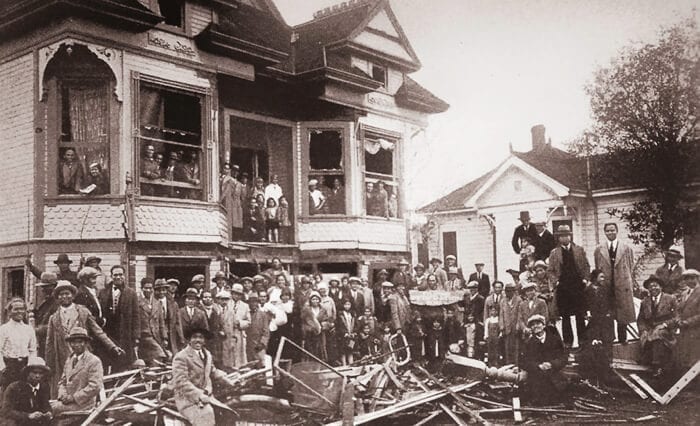 Filipinos stand in front of the bombed Filipino Federation of America in 1930