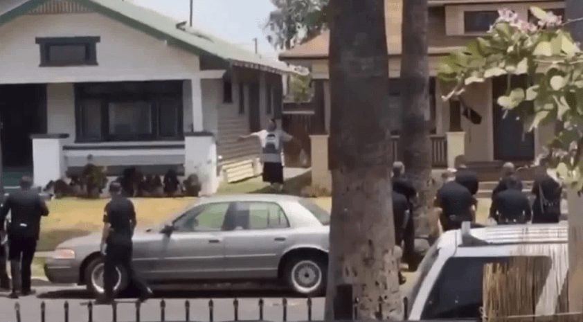 Jose Chavez stands while a dozen LAPD officers look back